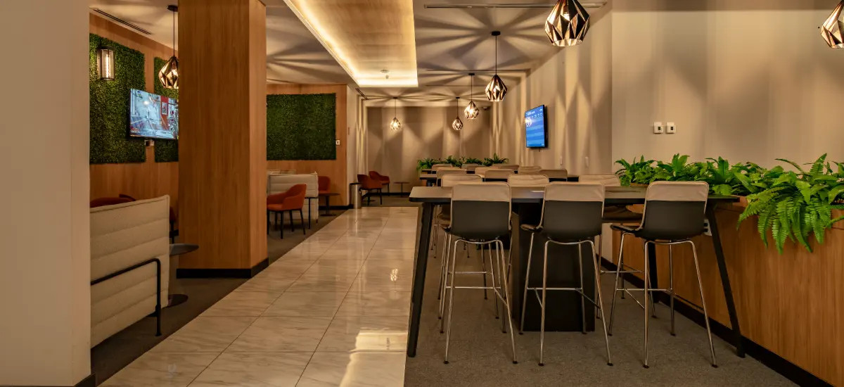 Vista general del salón con áreas de descanso y mesas altas