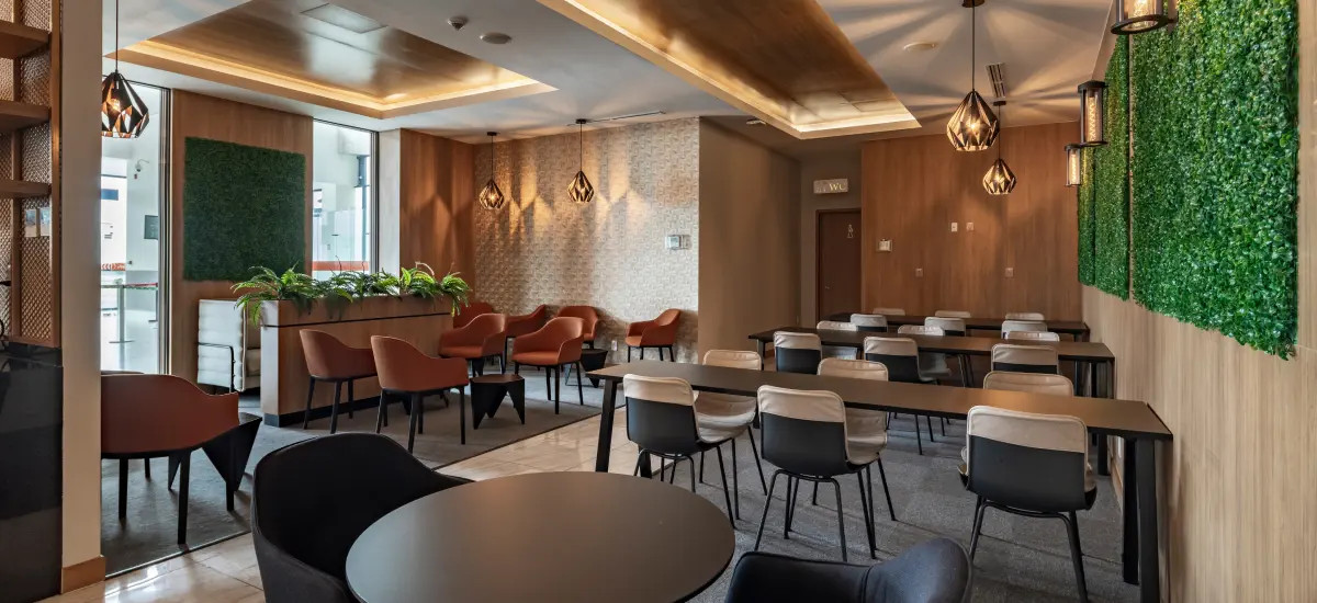 Vista general del salón con áreas de descanso y mesas altas